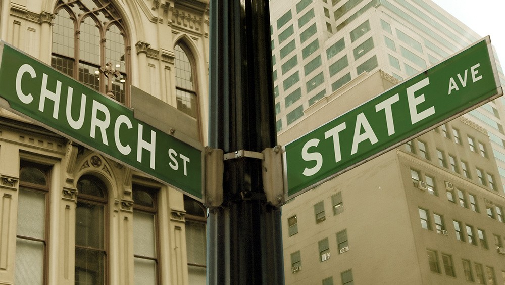 street signs with words "church" and "state" pointing in opposite directions representing separation of church and state