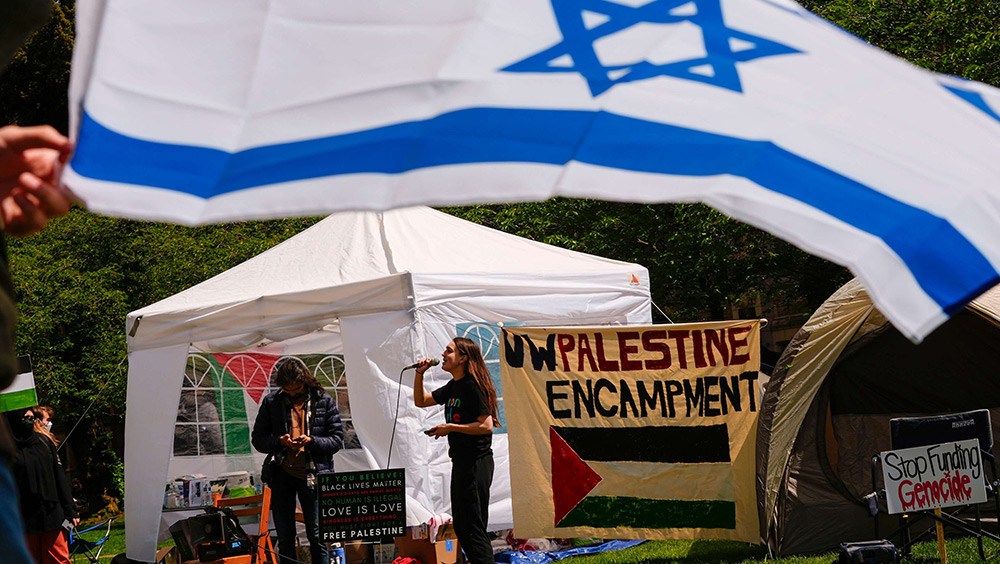 Pro-Palestine encampment with counter-protestor waving Israel flag