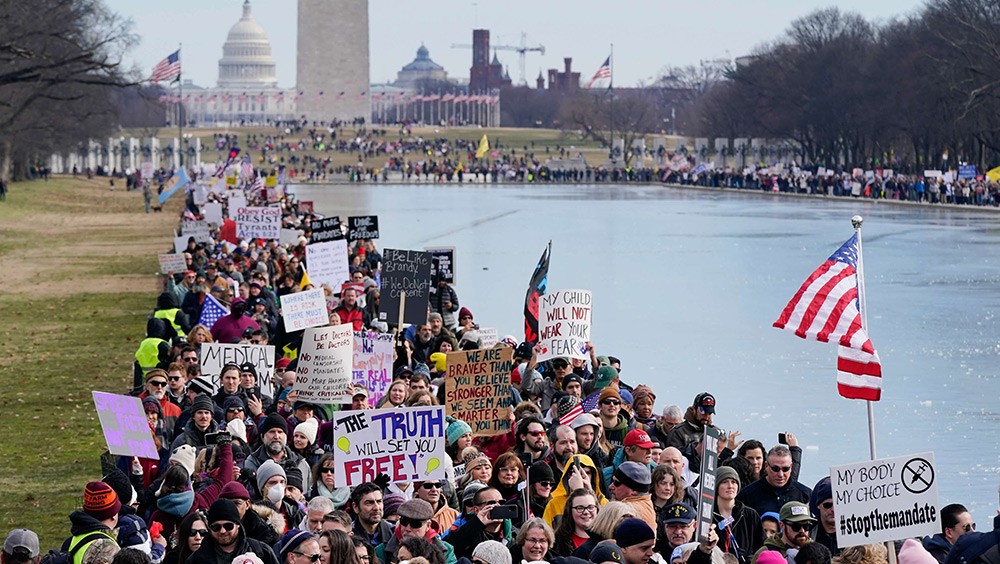 Freedom of assembly example showing people marching alongside the Lincoln Memorial Reflecting Pool before an anti-vaccine rally in Washington in January 2022.