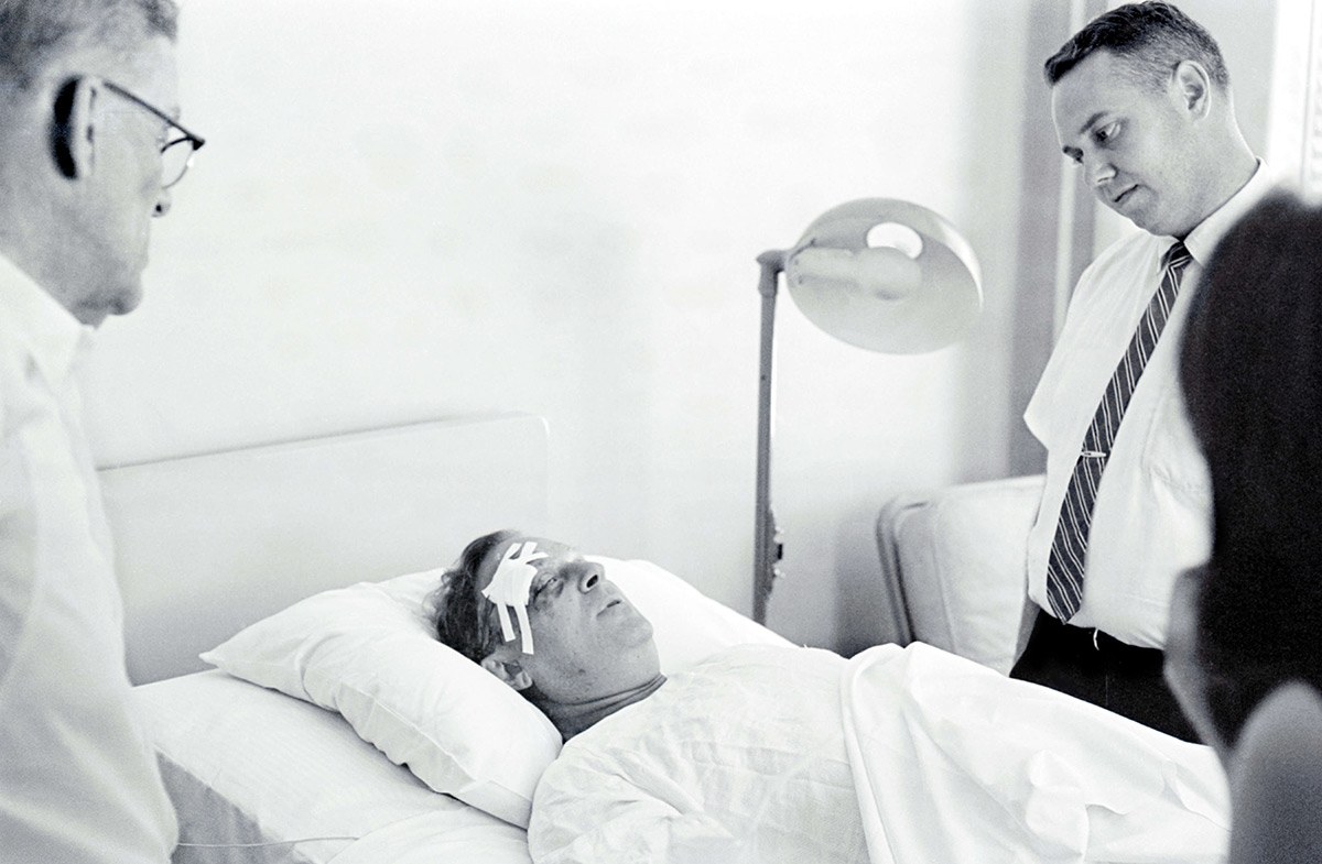 Rabbi Arthur J. Lelyveld lies in a hospital bed with a bandage on his forehead after being attacked in Hattiesburg, Mississippi, in July 1964.