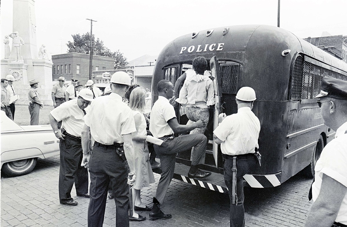 White officers round up demonstrators and watch as they step into a police wagon outside of the Leflore County Courthouse in Greenwood, Mississippi, on July 16, 1964. 