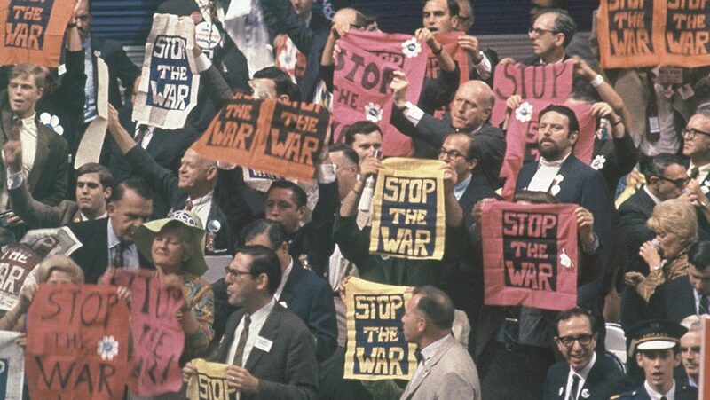Delegates on the floor of the 1968 Democratic National Convention holding up 