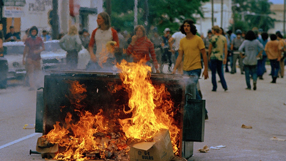 Demonstrators watch flaming trash in the middle of a street during the 1972 Republican National Convention.