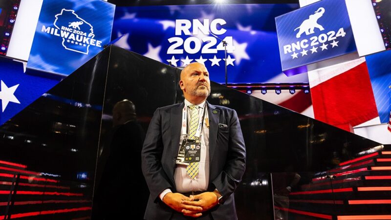 A U.S. Secret Service agent guards the main stage at Fiserv Forum during preparations for the 2024 Republican National Convention.