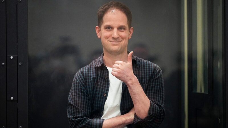 Wall Street Journal reporter Evan Gershkovich gives a thumbs up in a glass cage in a courtroom in Russia on April 23, 2024.