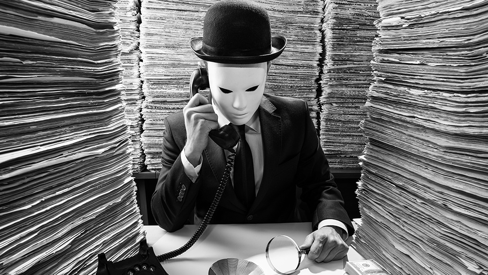 catch and kill journalism concept of masked man sitting in room full of newspapers on phone with stack of money