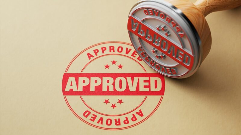 Wooden approval stamp on recycled paper