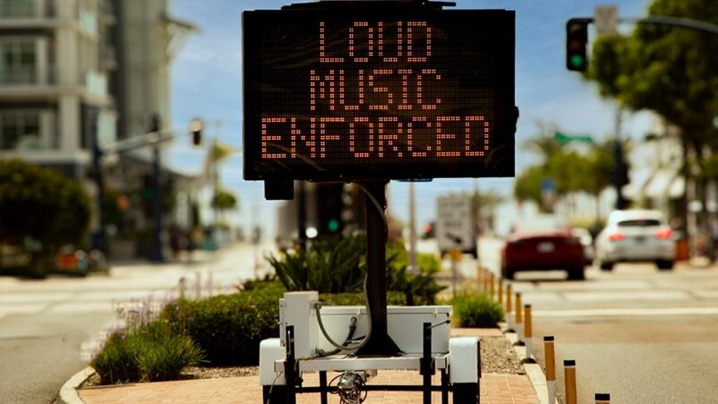 Digital sign stating Loud Music Enforced in an urban area in attempt to reduce loud music from cars or boom boxes