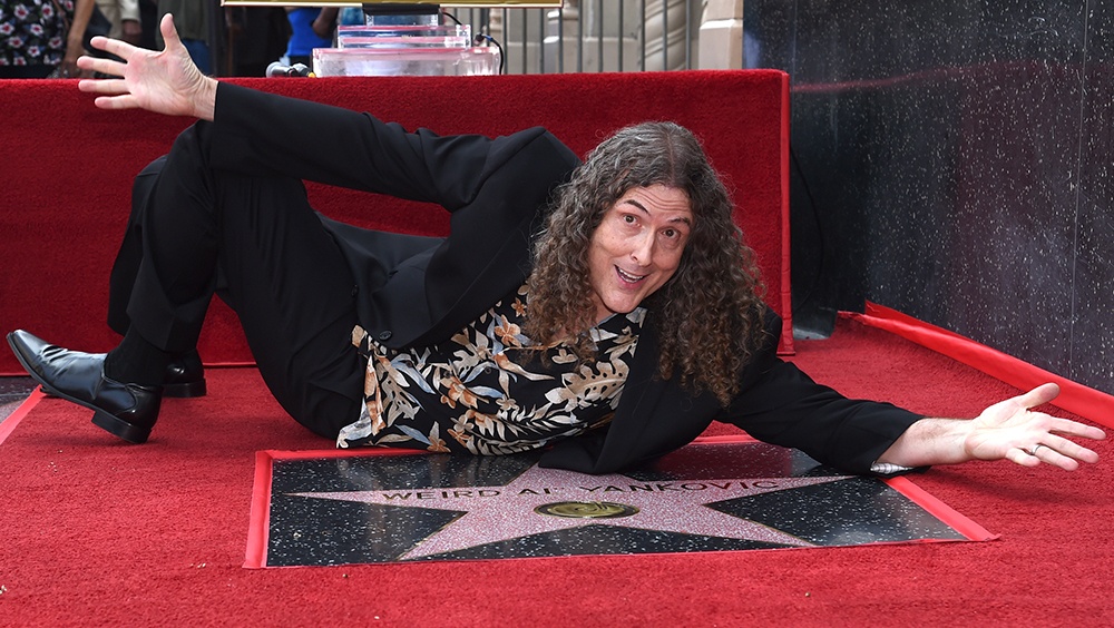 Musician/comedian "Weird Al" Yankovic, known for song parodies, poses atop his star on the Hollywood Walk of Fame.