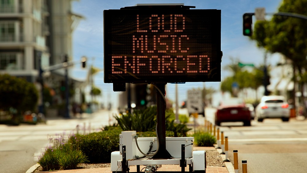 Electronic sign reading "loud music enforced"